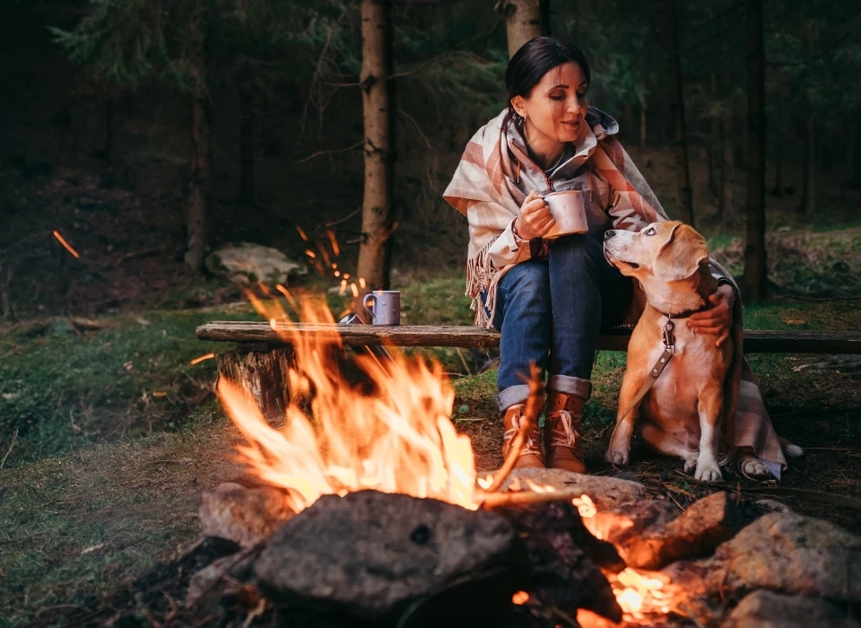 kobieta z psem przy ognisku